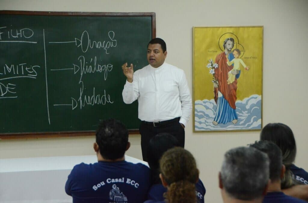 Casais se reúnem para catequese com o padre